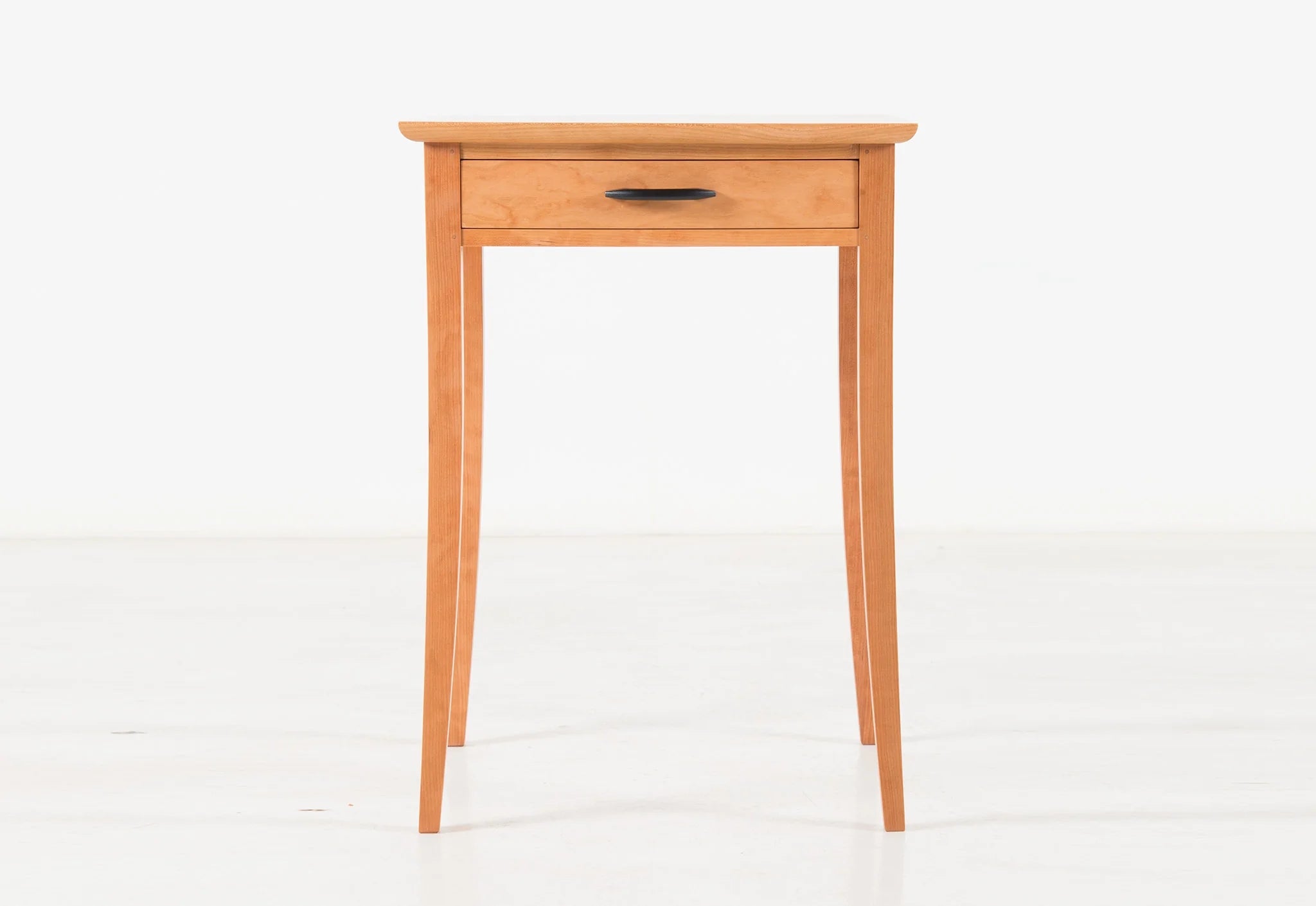 End Table - The embraces simplicity, marked by four hand-tooled legs that flow to a gentle curve as they ease to the